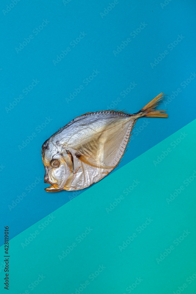 Smoked sea fishmoon on a colored background at an angle Smoked sea fishmoon on a colored background at an angle