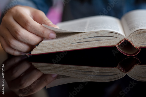 person reading a book on a table