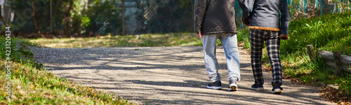 ワイド幅撮影した春の公園で散歩しているシニア夫婦の姿