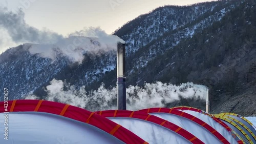Wallpaper Mural White smoke pours from the chimneys of two stoves of a large winter tent against the backdrop of the hills and forests of Olkhon Island. Frosty Lake Baikal, winter hike. Close-up. Torontodigital.ca