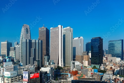 Obraz na plátně City skyline of modern high-rise buildings under blue clear sunny sky in Shinjuk