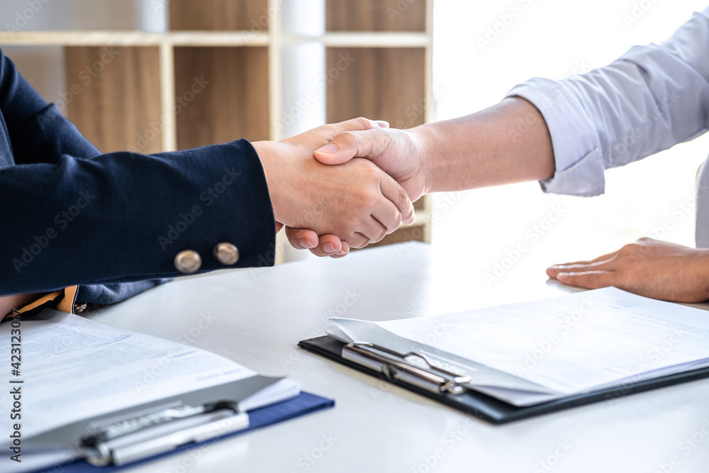 Greeting new colleagues, Handshake while job interviewing, Female candidate shaking hands with Interviewer or employer after a job interview, employment and recruitment concept Greeting new colleagues, Handshake while job interviewing, Female candidate shaking hands with Interviewer or employer after a job interview, employment and recruitment concept