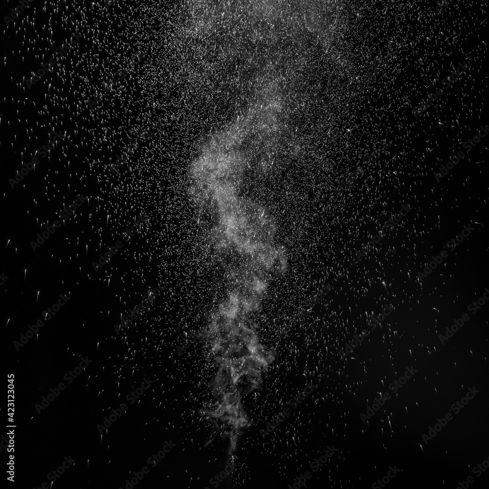 Obraz premium Curly white steam rising up and splashing water scattering in different directions isolated on a black background. Evaporation of liquid and condensation.