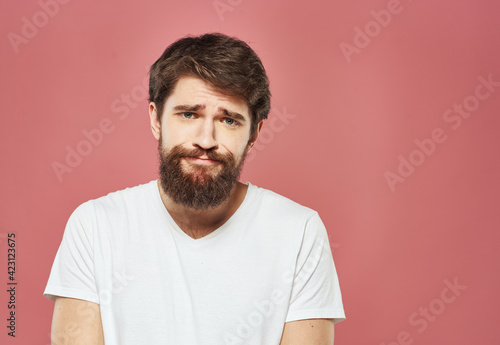 man grimacing on pink background cropped view Copy Space