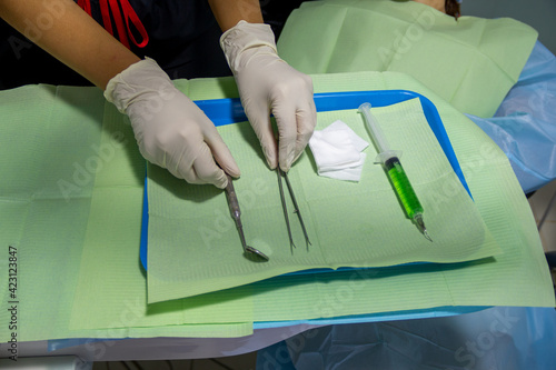Vista superior de una dentista con guantes estériles colocando elementos para realizar una revisión vocal