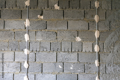 Installation of beacons for plaster walls. The wall of expanded clay blocks with installed beacons is ready for plaster.