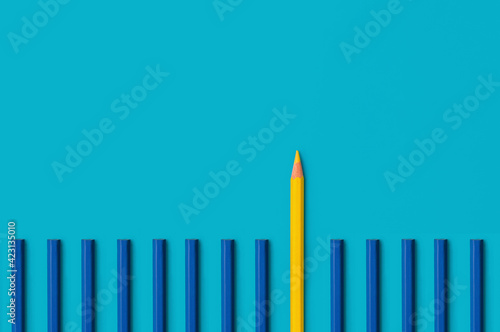 Business leadership concept  a yellow pencil that stands out from a lot of blue pencils. Standing out from the crowd of many identical ones.  Leadership  uniqueness  independence  dissent  think diffe