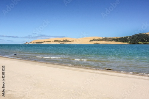 White sandy beach and azure sea  blue sky background  no people