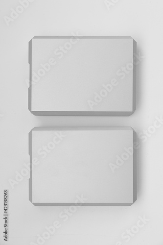 Two stylish aluminum external hard drives on a white background. Two backups of important data. Data storage rules.