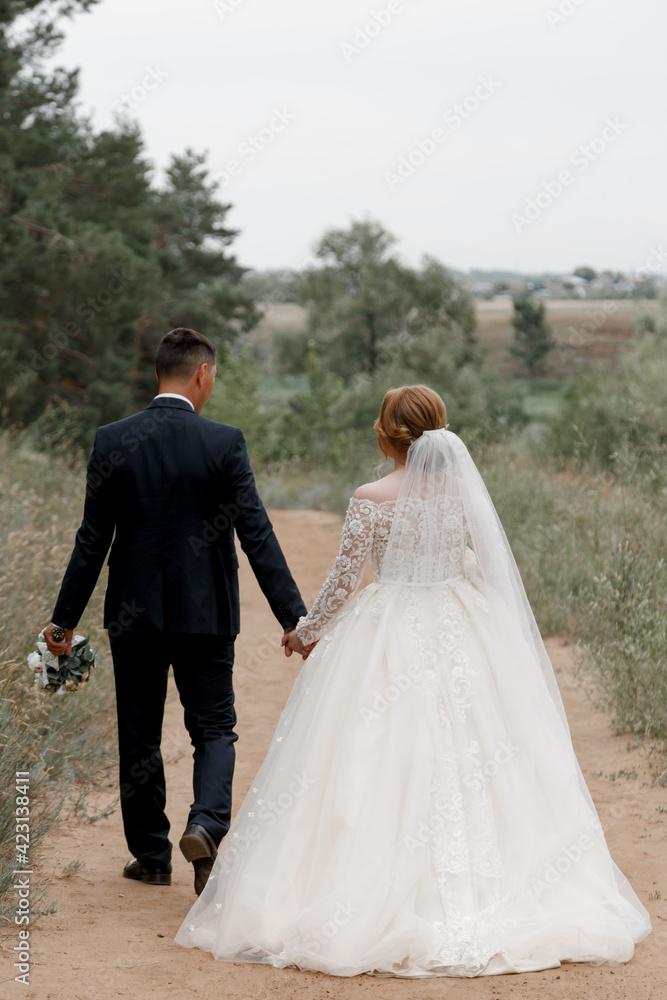 bride and groom walking in the park