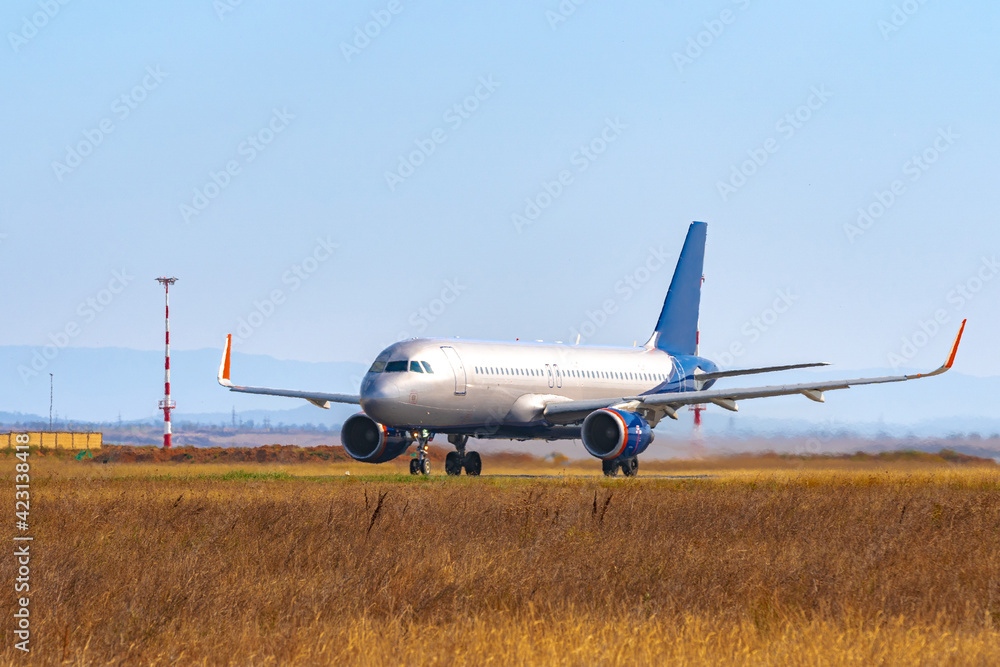 Fototapeta premium Big passenger airplane drives along the runway in airport