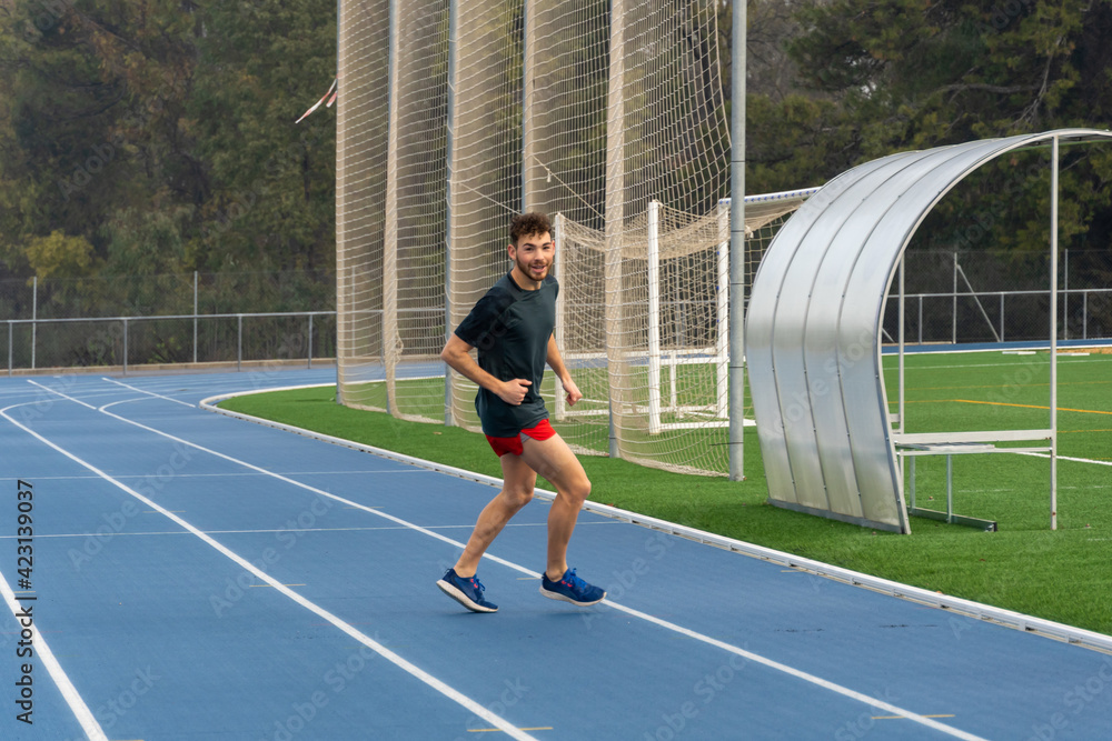 Fototapeta premium Hard working runner practicing in blue running track.