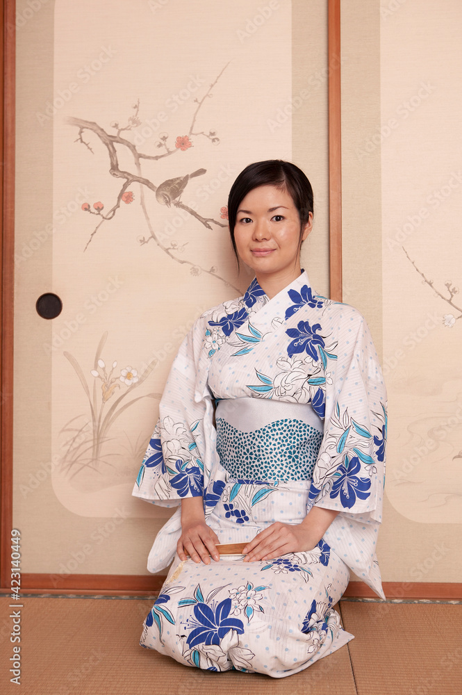 Portrait beautiful young woman in floral kimono at painted screen door
Portrait beautiful young woman in floral kimono at painted screen door
