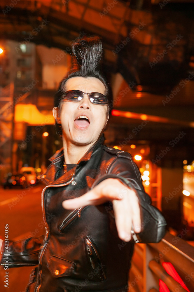 Portrait exuberant man with mohawk in city street at night
Portrait exuberant man with mohawk in city street at night