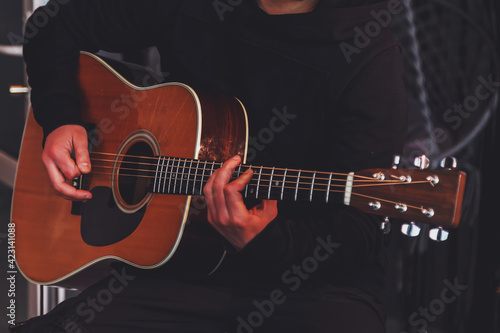 Guitar man holding in hands and players acoustic guitar. Playing for music concept. Play live staying home for audience during quarantine and isolation lockdown due coronavirus. Copy space for site