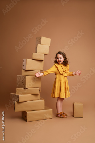 Girl pointing to a large pile of gifts standing nearby