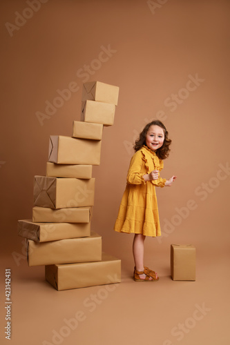Girl staying next to a large pile of gifts