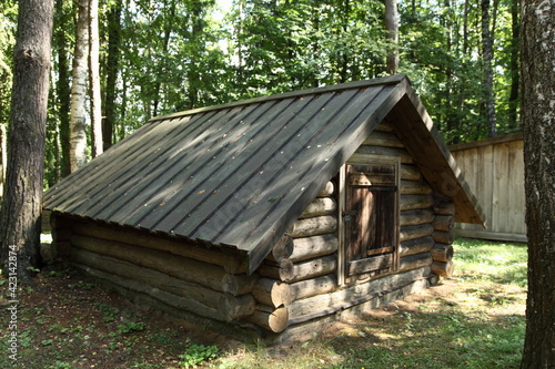 Beautiful traditional rural Russian log cabin old wooden dugout barn in the green forest at Sunny summer day