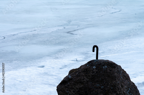 Obraz na plátně An iron hook attached to a rock by the frozen sea
