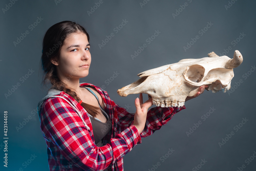 Young girl holds the skull of a horned animal