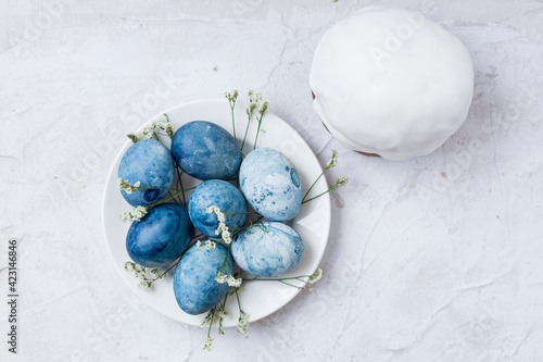 Close-up of blue painted traditional eggs and Easter cake for Easter holiday on grey background. Selective focus