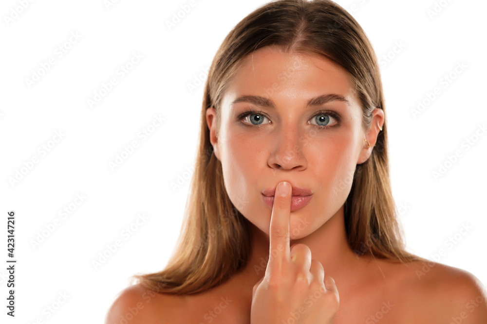 Young woman kissing her finger Young woman kissing her finger