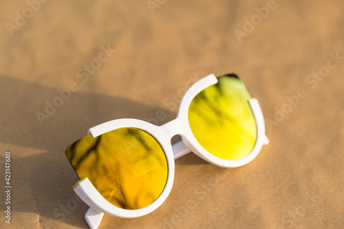 Cat eye sunglasses special model for women golden lenses and whit frames color shoot outside in a summer day closeup. Selective focus . High quality photo