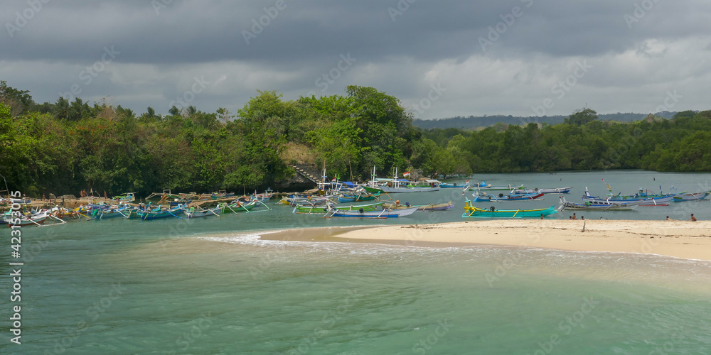 Panorama view of Pero village fishing harbor with wooden outrigger boats and turquoise water, Sumba island, East Nusa Tenggara, Indonesia