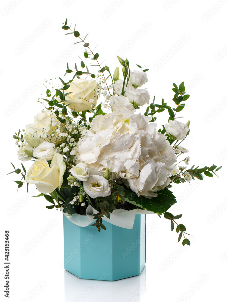 Floral arrangement of white roses, white hydrangea and eucalyptus leaves in a blue box on a white background.
