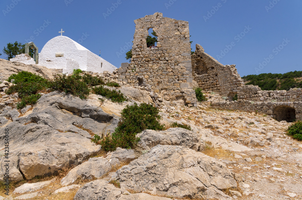 Courtyard of the Monolithos fortress with the Orthodox Church and the ruins of the tower (Rhodes, Greece)