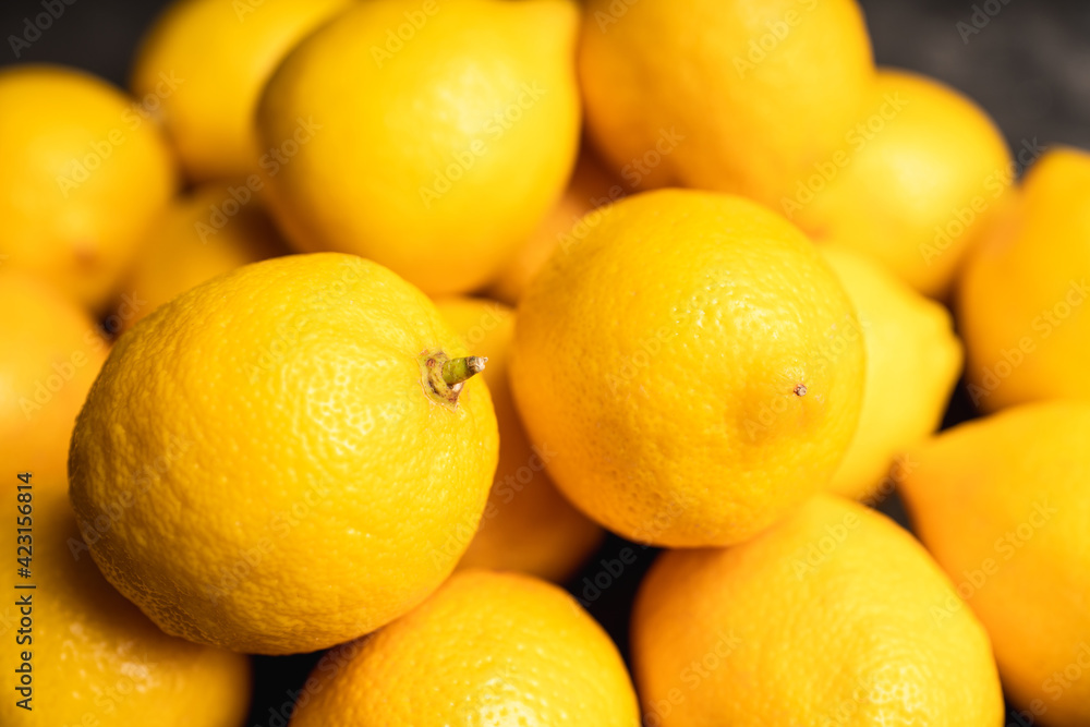 Ripe bright lemons on the dark rustic background. Selective focus. Shallow depth of field. Ripe bright lemons on the dark rustic background. Selective focus. Shallow depth of field.