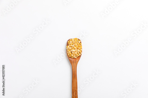 dry and organic chickpea pulses in wooden spoon on white background