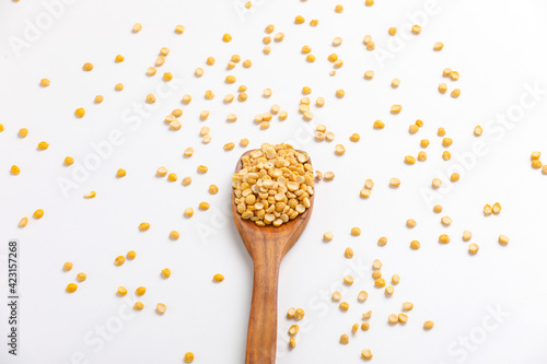 dry and organic chickpea pulses in wooden spoon on white background