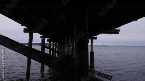 Wallpaper Mural Pan under pier at park with grey sky and clouds in the sky over the ocean horizon dark creepy peaceful Torontodigital.ca