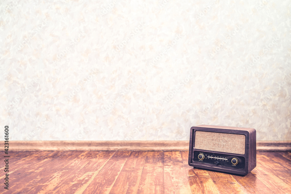 Retro vintage radio background with old wall paper texture pattern. Nostalgia music backdrop and wallpaper. 50s style stereo receiver and speaker on wooden floor. Rustic propaganda news show banner. - obrazy, fototapety, plakaty 