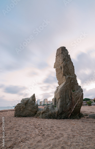 Platja d'Aro beach, in the foreground the granite stone monolith "Cavall Bernat"