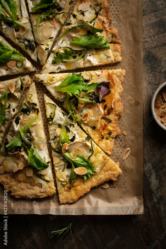 pizza coupée en part avec fromage, courgette, pesto et salade pizza coupée en part avec fromage, courgette, pesto et salade