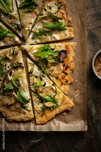 pizza coupée en part avec fromage, courgette, pesto et salade photo