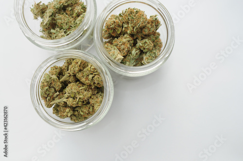 Marijuana buds storage. Medicinal cannabis flowering on white background, isolated, top view. Hemp recreation, medical usage, pastime.