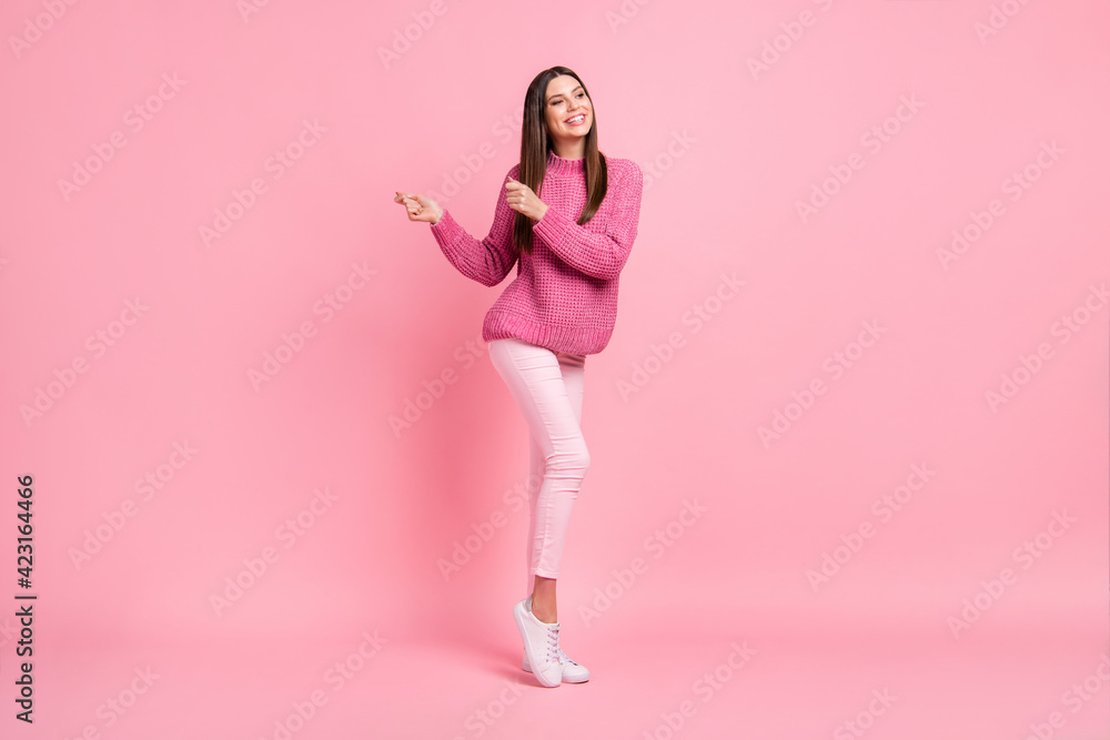 Photo of funny charming young lady wear knitted pullover dancing smiling isolated pink color background Photo of funny charming young lady wear knitted pullover dancing smiling isolated pink color background