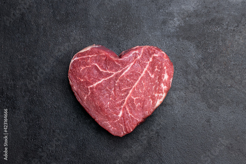 Heart shape raw fresh beef steak on metal background