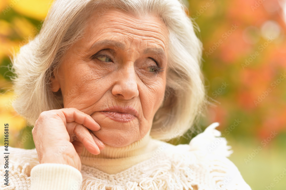 sad senior woman in autumn park sad senior woman in autumn park