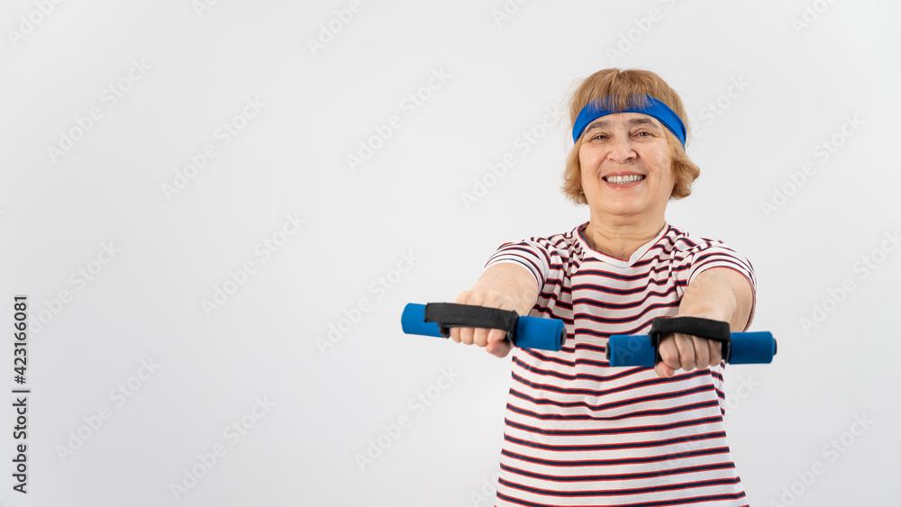 Happy old woman doing fitness exercises with dumbbells on a white background. Elderly lady doing fitness to maintain health. Happy old woman doing fitness exercises with dumbbells on a white background. Elderly lady doing fitness to maintain health.