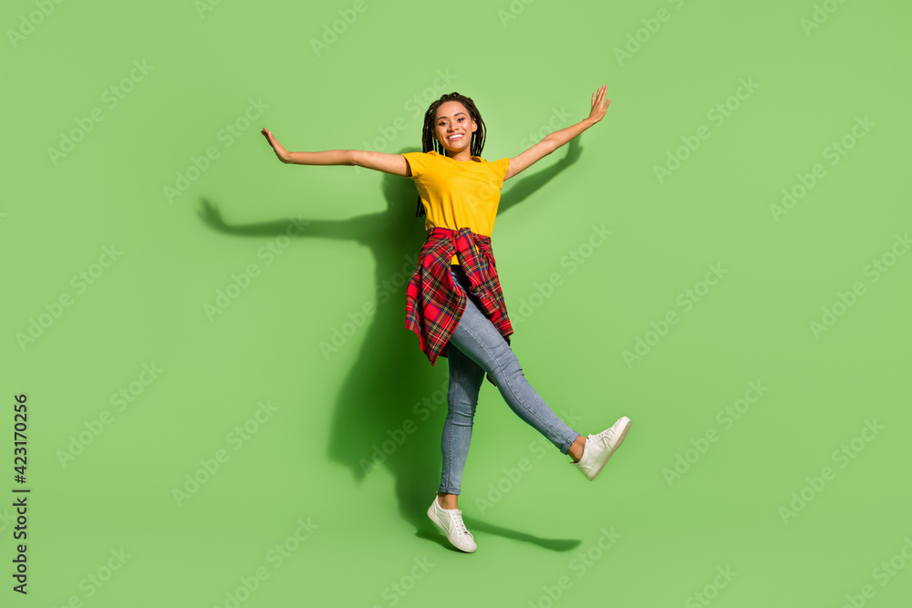 Full length photo of pretty sweet dark skin lady dressed yellow t-shirt dancing hands arms sides isolated green color background