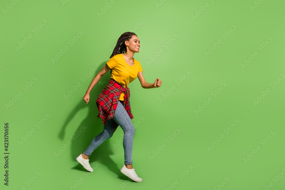 Full length body size view of lovely cheerful girl jumping running fast having fun isolated over bright green color background Full length body size view of lovely cheerful girl jumping running fast having fun isolated over bright green color background