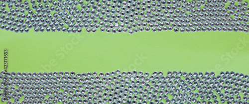 rhinestones on a green background, top photo. design for text