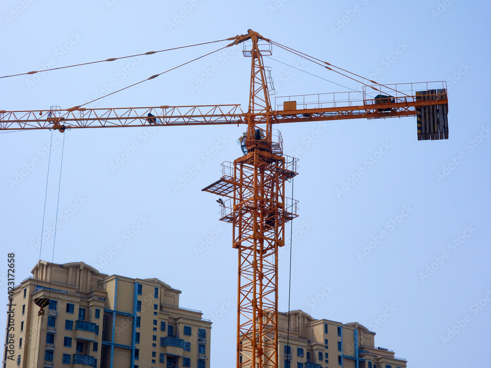 The tower crane on the construction site is busy working The tower crane on the construction site is busy working