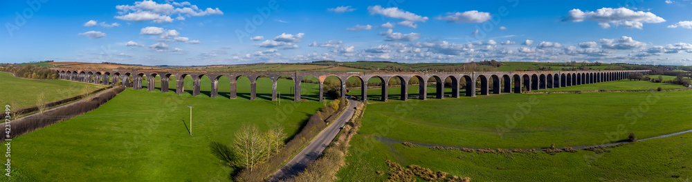 Fototapeta premium A panorama aerial view of the 82 arches of the Welland Valley viaduct on a bright sunny spring day in the UK