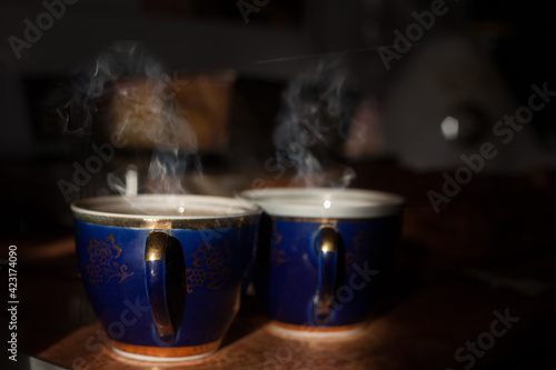 Cups of green tea in a beautiful cup. Retro style. A mug of tea with spectacular smoke. Wooden background. 