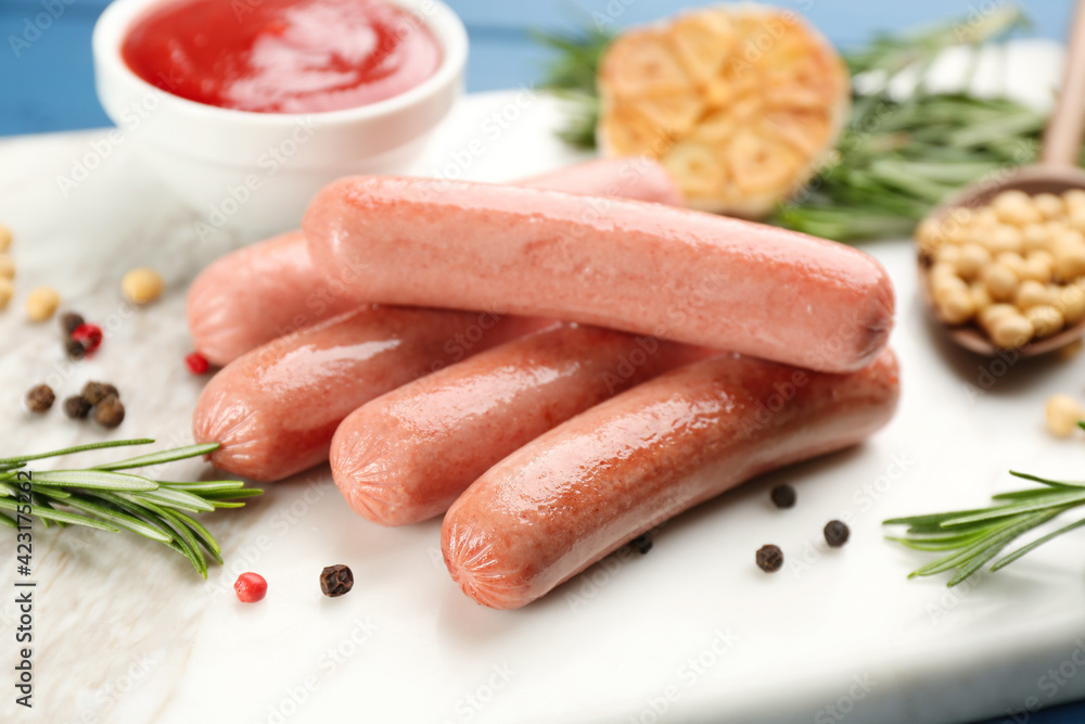 Delicious vegetarian sausages with rosemary and pepper on white marble board, closeup Delicious vegetarian sausages with rosemary and pepper on white marble board, closeup